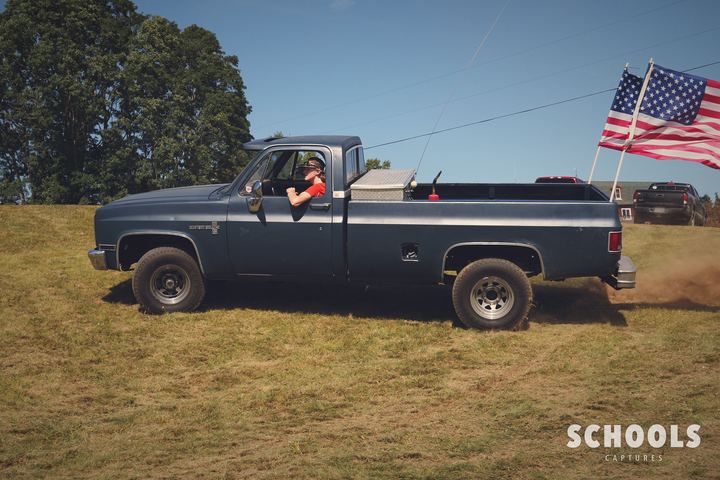 Dark blue with flag doing donuts on grass